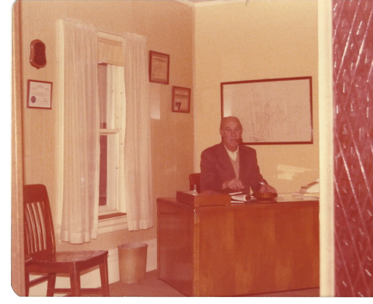 Old time photo of a man sitting behind a desk