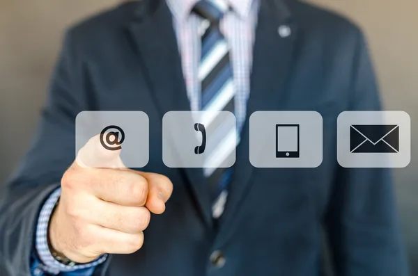 A man in a business suit pointing at a display showing methods of contacting